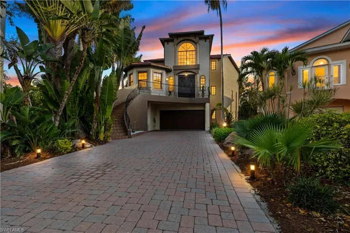 Mediterranean / spanish-style house with stucco siding, decorative driveway, an attached garage, and a balcony