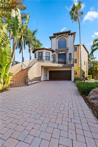 Mediterranean / spanish home with stucco siding, a balcony, driveway, and a garage