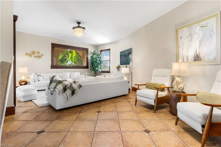 Tiled living area featuring baseboards
