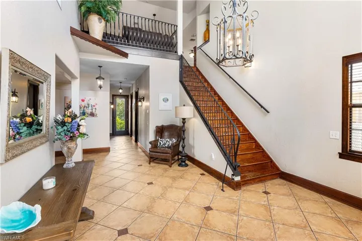 Entryway with a high ceiling, suspended lighting, and light tile patterned floors