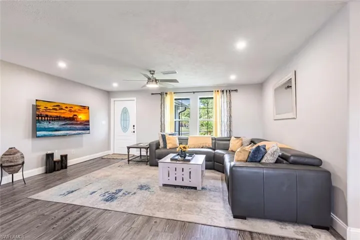 Living area featuring a ceiling fan, wood finished floors, and recessed lighting