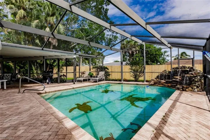 View of pool featuring a fenced backyard, patio surround, and a lanai