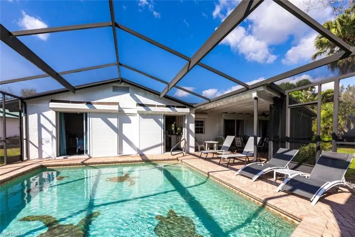 Outdoor pool with a sunroom, a patio area, and a lanai