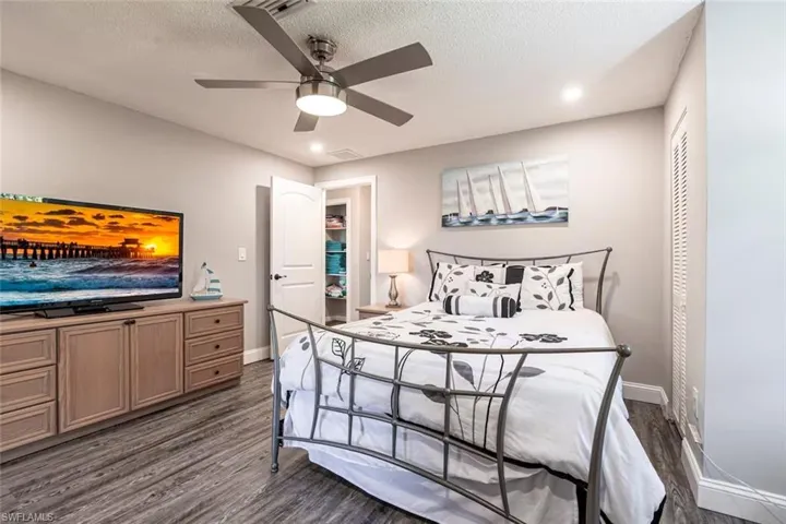 Bedroom featuring a ceiling fan, recessed lighting, dark wood-style floors, and a textured ceiling