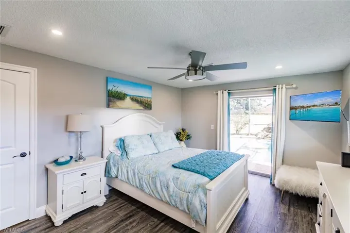 Bedroom featuring access to outside, dark wood-style flooring, a textured ceiling, a ceiling fan, and recessed lighting