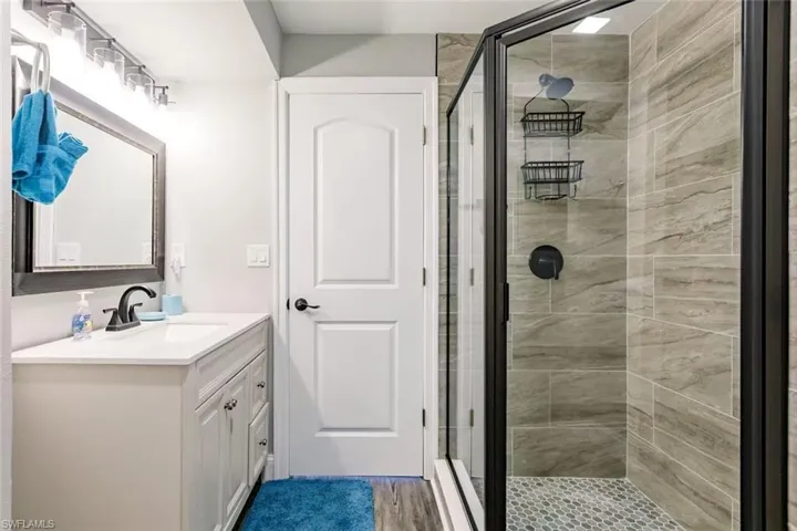 Bathroom with a stall shower, vanity, and light wood-style flooring
