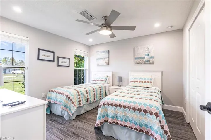Bedroom with dark wood-style floors, ceiling fan, a closet, and recessed lighting