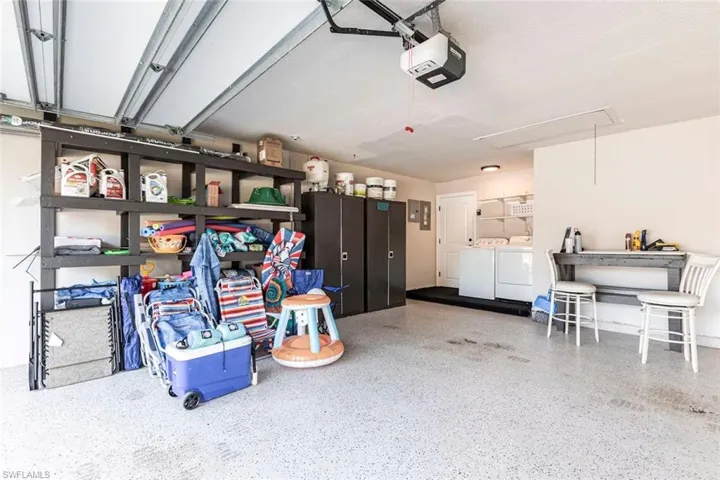 Garage featuring washing machine and clothes dryer and a garage door opener
