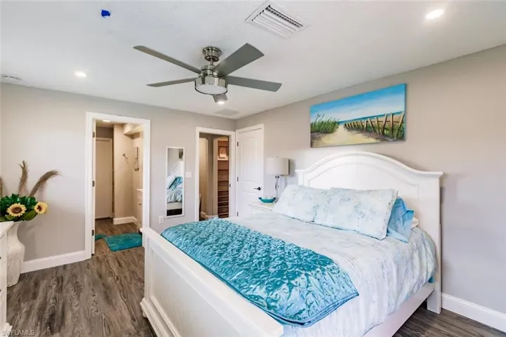 Bedroom featuring dark wood finished floors, a ceiling fan, connected bathroom, and recessed lighting