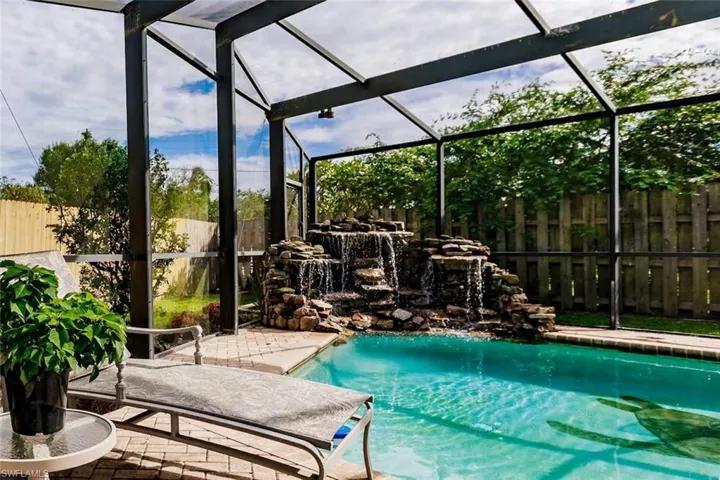 View of pool with a fenced backyard, a lanai, and a sunroom