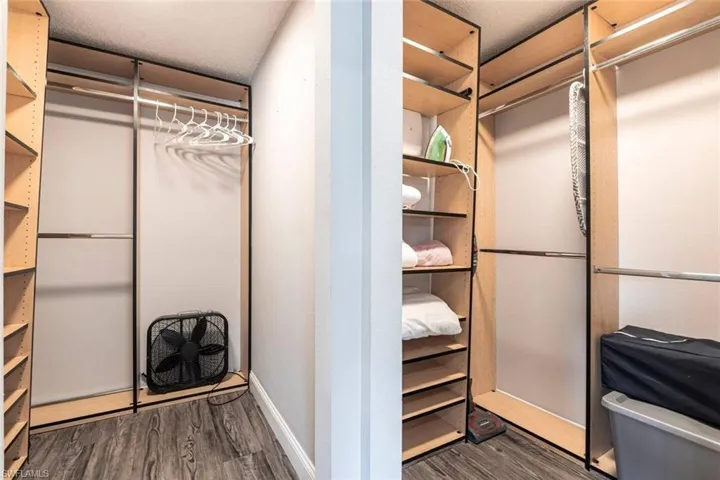 Walk in closet with dark wood finished floors