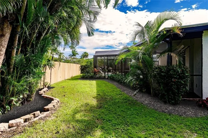 Fenced backyard featuring a lanai and a sunroom