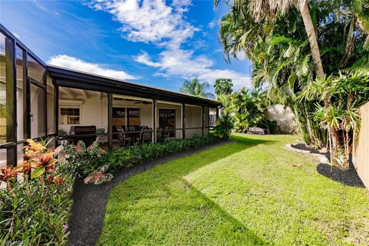 View of yard with a sunroom and a ceiling fan