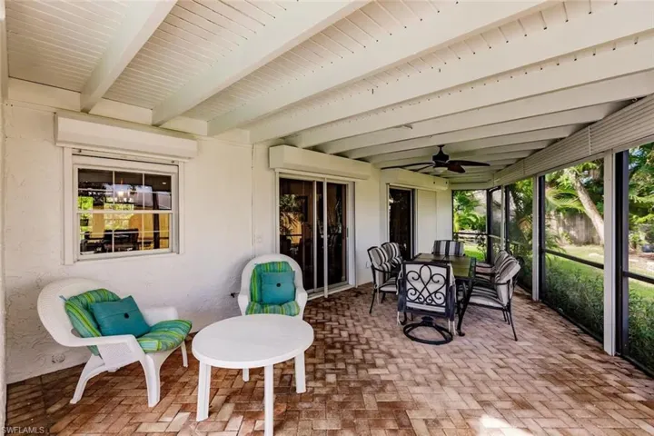 Sunroom / solarium featuring outdoor dining space, ceiling fan, and beamed ceiling