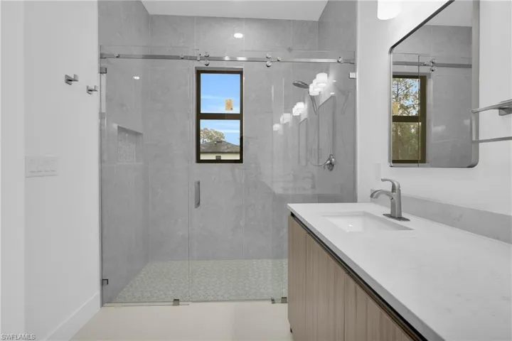 Bathroom with vanity, a stall shower, healthy amount of natural light, and light tile patterned floors