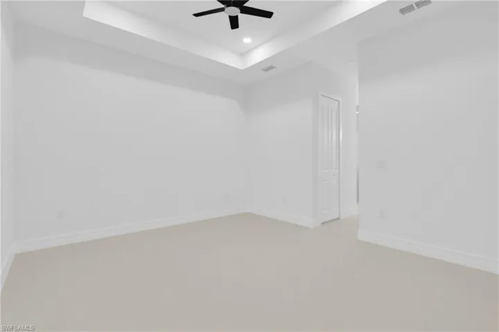 Unfurnished room with a tray ceiling, ceiling fan, recessed lighting, and light tile patterned flooring