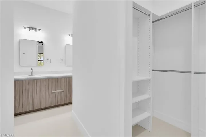 Bathroom featuring light tile patterned flooring, vanity, and a closet