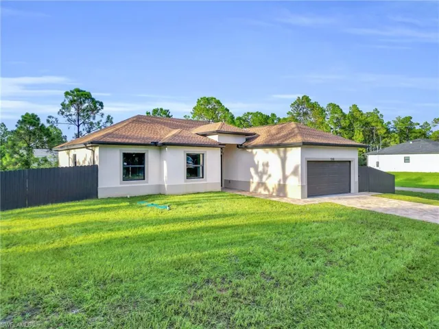 View of front facade with decorative driveway, stucco siding, and an attached garage