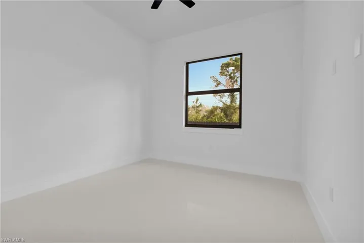 Empty room featuring a ceiling fan and light tile patterned floors
