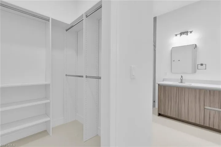 Bathroom featuring vanity and a walk in closet