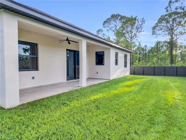 Rear view of property featuring stucco siding, a ceiling fan, and a patio