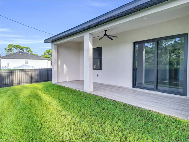 Rear view of property featuring a ceiling fan, stucco siding, and a patio area