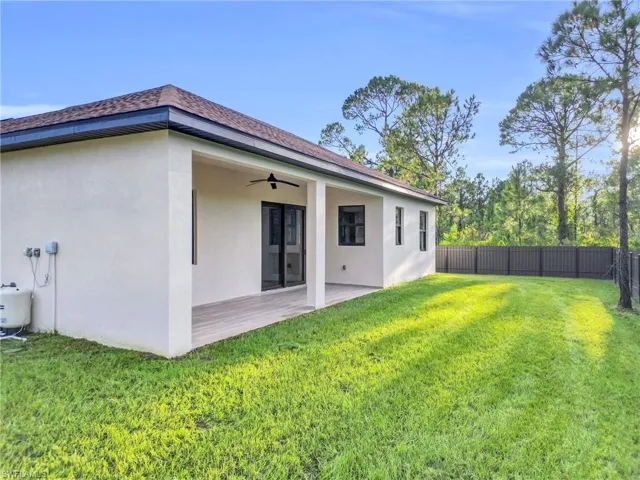 Rear view of house with a ceiling fan, stucco siding, a patio, and roof with shingles