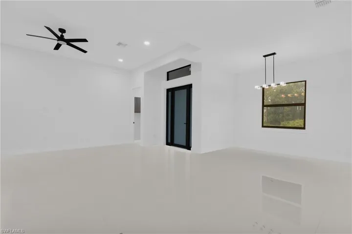 Empty room featuring recessed lighting, light tile patterned floors, and a chandelier
