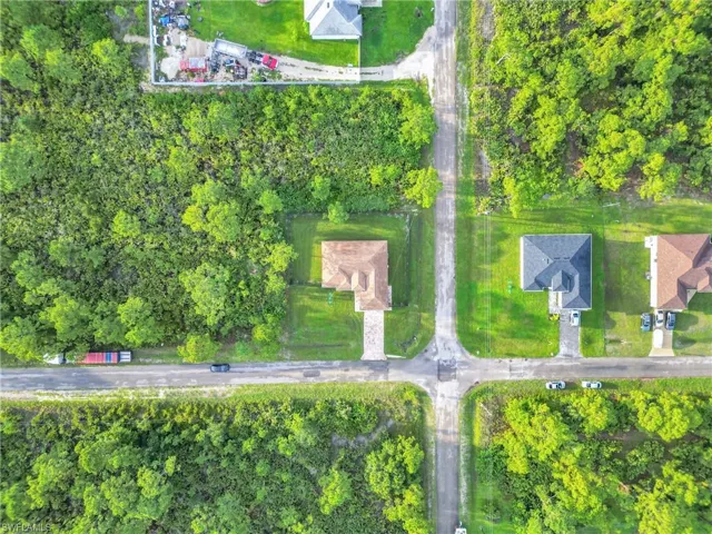 Aerial view of property's location featuring a tree filled landscape