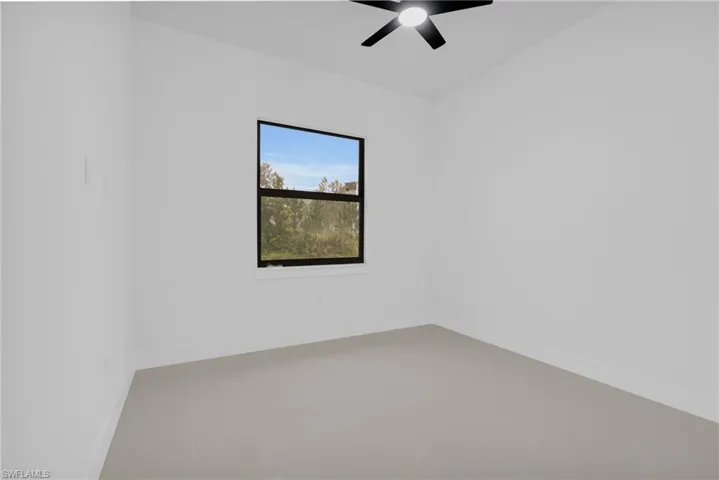 Empty room featuring baseboards and a ceiling fan