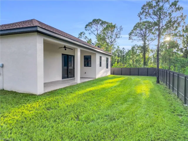 Fenced backyard featuring a ceiling fan and a patio area