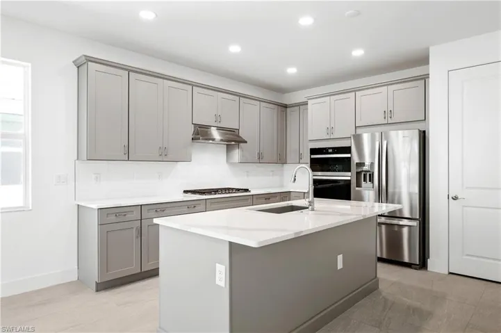 Gorgeous kitchen layout with wood cabinetry and quartz countertops