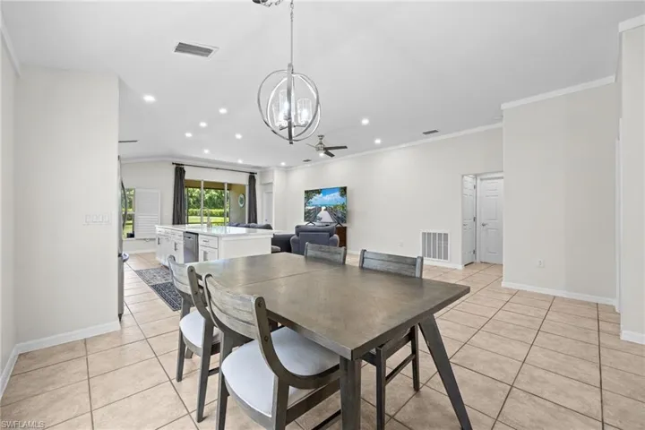 Open-concept living space featuring tile flooring, recessed lighting, and a contemporary chandelier