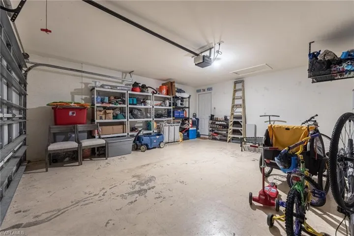 Attached garage with exposed ceiling joists and a concrete floor
