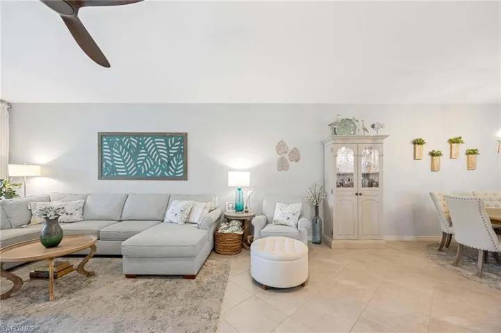 Living area featuring light tile patterned flooring and ceiling fan