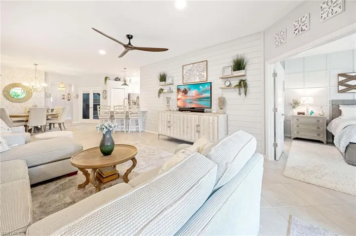 Living room featuring a chandelier, ceiling fan, and light tile patterned floors