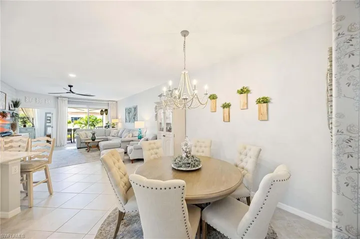 Dining room featuring a chandelier, light tile patterned flooring, and a ceiling fan