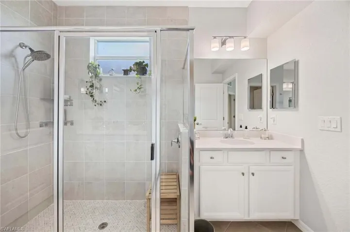 Bathroom with vanity, a stall shower, and tile patterned floors