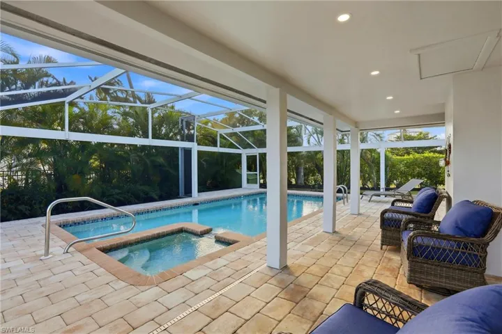 View of swimming pool with a patio area, a sunroom, a lanai, and a pool with connected hot tub
