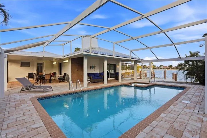 View of swimming pool featuring a lanai, a sunroom, an outdoor living space, and a patio