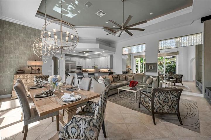 The expansive family room and dining room have views out to the pool, with reflections of the sunny views from the mirrored walls.