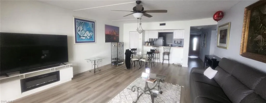 Living room with ceiling fan and light hardwood / wood-style flooring