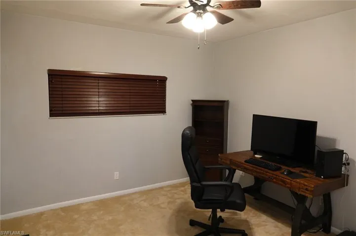 Office area featuring carpet floors and ceiling fan