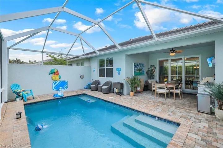 View of swimming pool featuring ceiling fan, a lanai, and a patio area