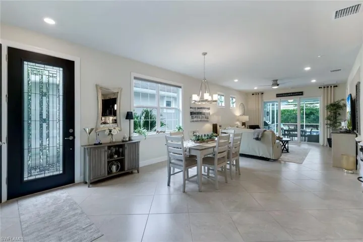 Tiled dining area with a wealth of natural light and ceiling fan with notable chandelier