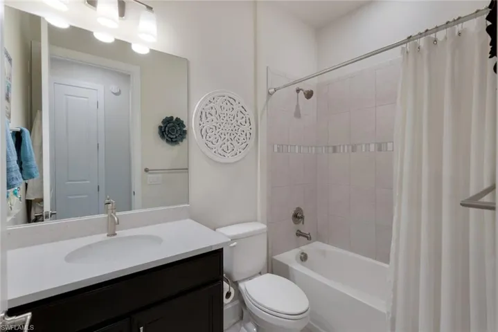 Full bathroom featuring vanity, toilet, and shower / tub combo with curtain