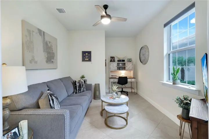 Living room featuring ceiling fan, plenty of natural light, and light tile patterned floors