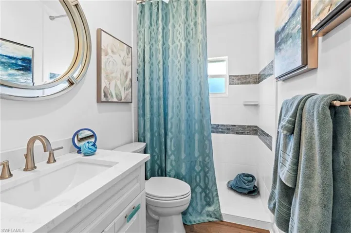Bathroom featuring a tile shower and vanity
