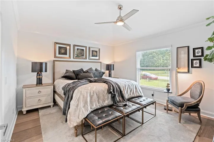 Bedroom with ornamental molding, light wood finished floors, and ceiling fan