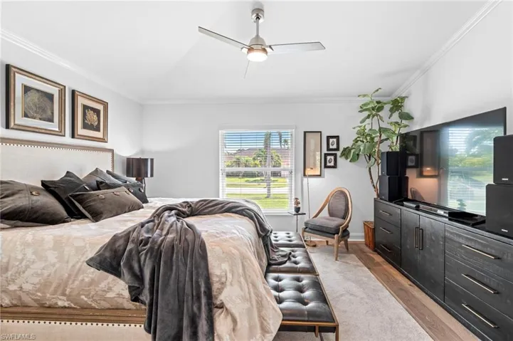 Bedroom featuring ornamental molding, wood finished floors, and ceiling fan